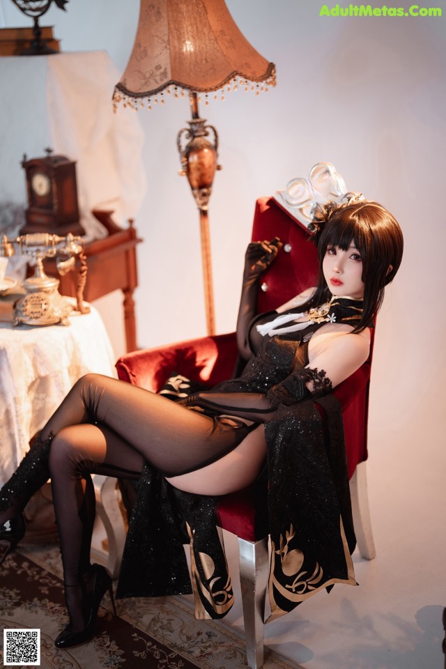 A woman sitting on a red chair in a room.