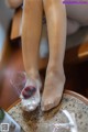 A woman sitting on a table with a glass of wine.