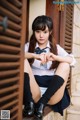 A young woman sitting on the steps of a building.