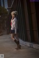 A woman in a school uniform is walking down the street.