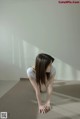 A woman crouching down on the floor in a room.