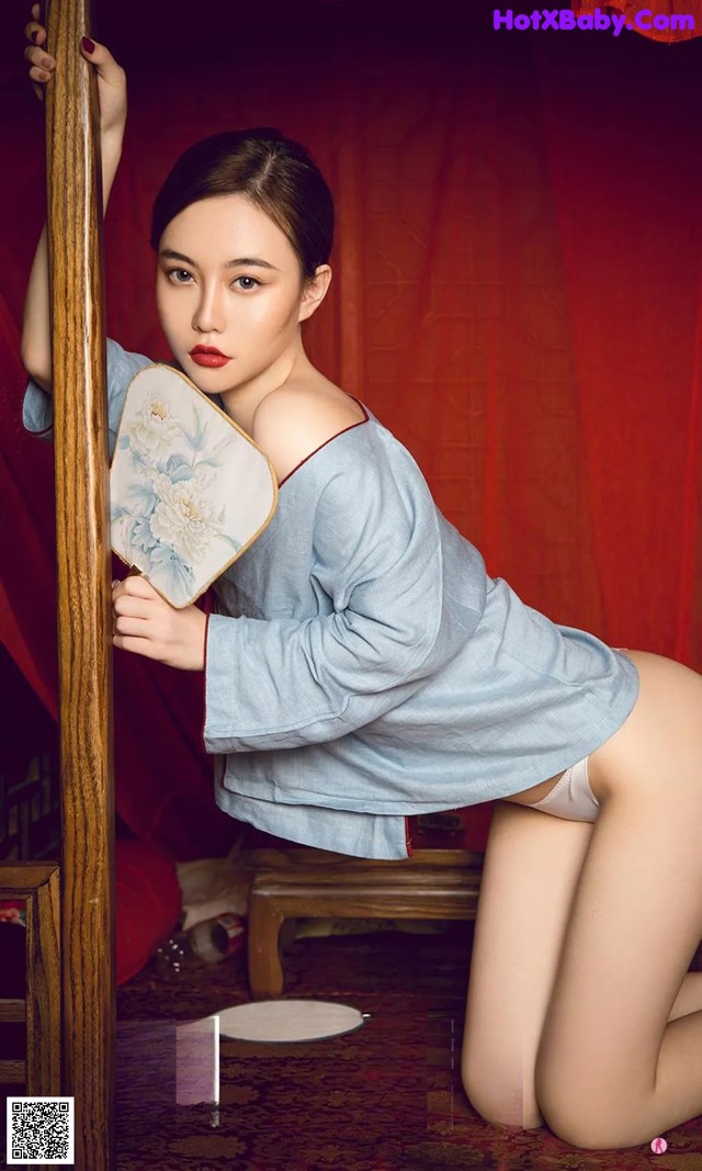 A woman in a blue dress is posing for a picture.