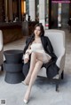 A woman sitting on a chair in a hotel lobby.