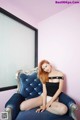 A woman sitting on a blue chair in a room.