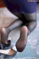 A close up of a woman's feet in black stockings and high heels.