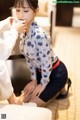 A woman sitting on the floor with a cup of coffee.