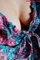 A close up of a woman's breasts in a floral dress.