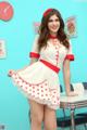 A woman in a white and red polka dot dress posing for a picture.