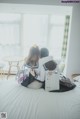 A couple of women sitting on top of a bed.