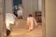 A woman in a pink dress is bending over on the floor.