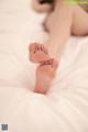 A woman laying on top of a bed with her feet up.