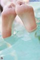 A pair of feet in a pool of water.