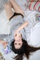 A woman laying on a bed with a stuffed animal.