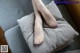 A woman's feet on a pillow on a couch.