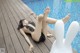 A woman laying on the edge of a swimming pool.