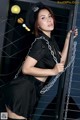 A woman in a police uniform is chained to a fence.