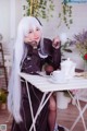 A woman sitting at a table with a cup of coffee.