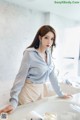 A woman standing in front of a sink in a bathroom.