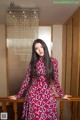 A woman in a red and blue dress standing on a staircase.